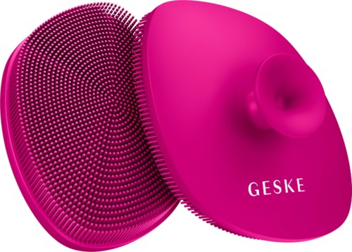 Ein rosa Gesichtsreinigungsbürste mit weichen Silikonborsten und einem runden Zubehör.
