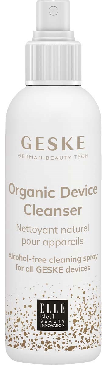 White spray bottle labeled as organic device cleanser, with gold and black text, and small gold dots design.