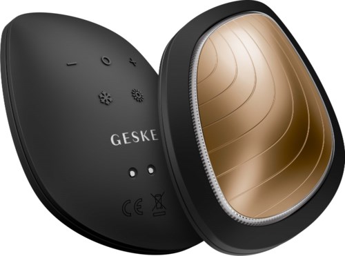 Ein kleiner schwarzer Gerät mit einer goldenen ovalen Polsterung, markiert 'GESKE', scheint ein Massage- oder Therapiegerät zu sein.