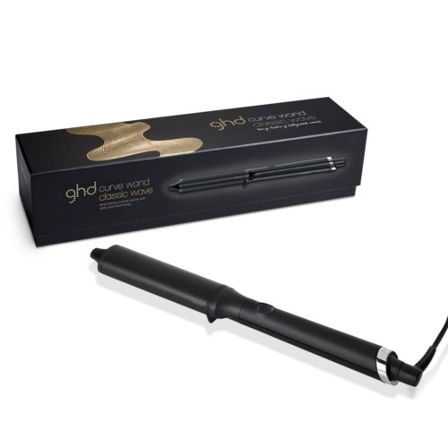 A black pen-shaped device with a cord, placed in front of a box labeled 'ghd curve wand classic wave.'