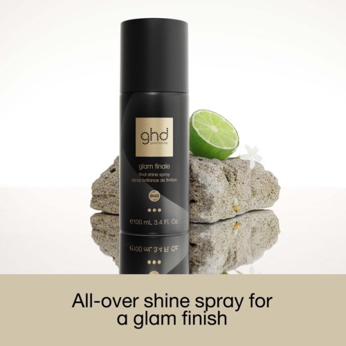 Ghd finisherspray på steiner med lime og hvit blomst, gir glans for en glamorøs look.