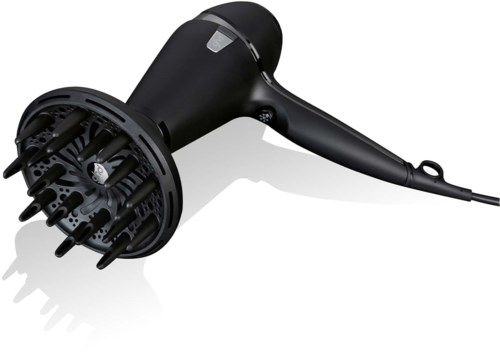 A black hair dryer with a rounded head and a long handle, lying on a white surface.