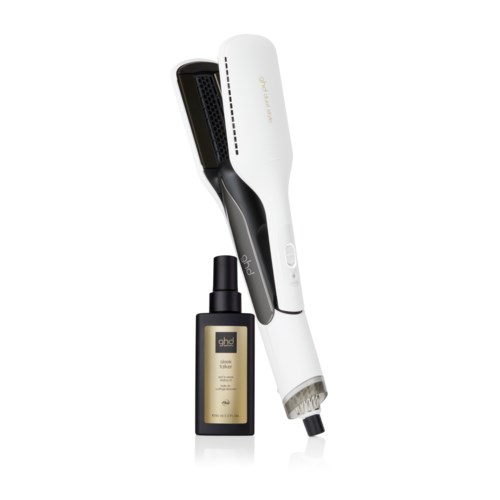 A white and black hair straightening tool with a bottle of hair treatment serum beside it.