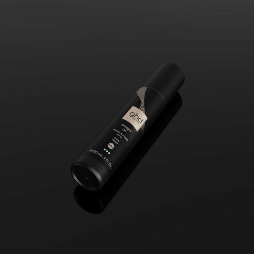 A black cylindrical container with a label, lying on a black surface, possibly a spray or deodorant.