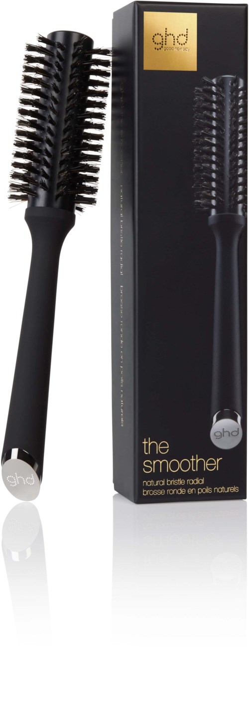 A hairbrush with a black handle and round bristles, standing next to a long black box.
