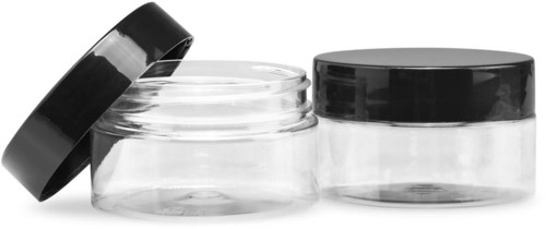 Twee lege glazen potten met zwarte deksels, één deksel ligt open. Duidelijke containers op een witte achtergrond.