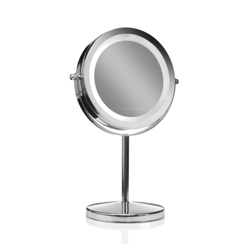 Een ronde, moderne make-up spiegel op een standaard met een reflecterend oppervlak en een slank ontwerp.
