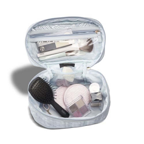 Reistas voor toiletartikelen met borstels, cosmetica en kleine persoonlijke spullen.