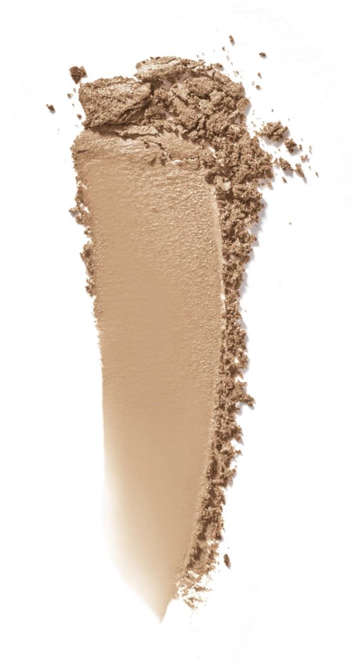 En beige pulver knust i spredte biter på hvit bakgrunn.