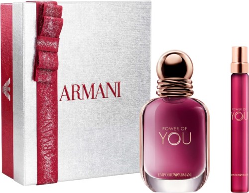 Armani perfume bottle with pink liquid next to a matching lipstick and gift box.