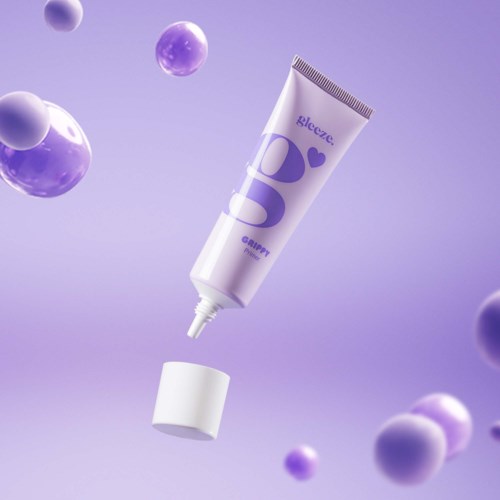 Eine Tube Hautcreme mit lila Elementen und schwebenden Kugeln im Hintergrund.