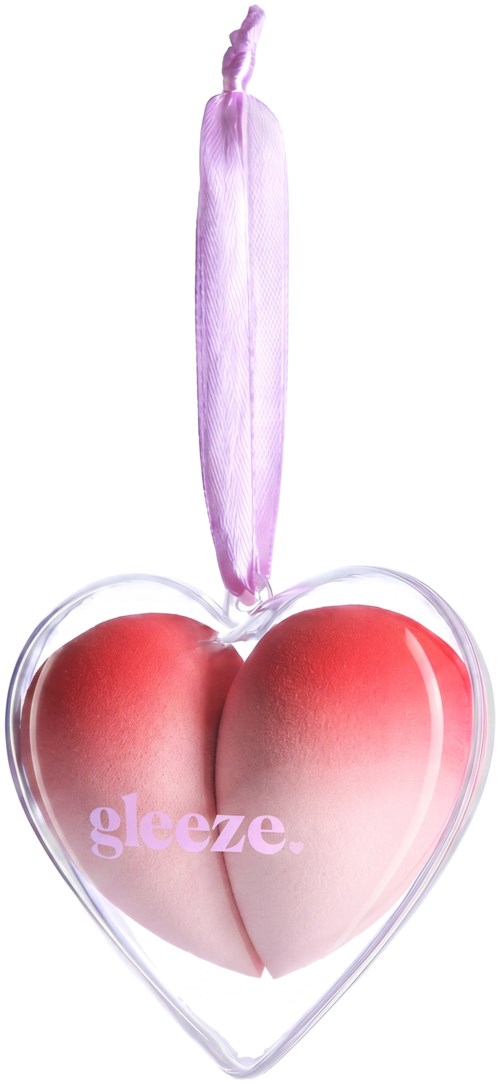 Ett hjärtformat ljuslyktor med ett rosa ljus på en vit bakgrund, med ordet gleze på hjärtat.