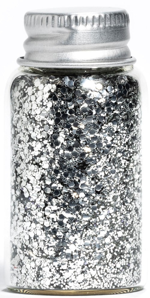 Ein kleiner Glasbehälter gefüllt mit silbernem und schwarzem Glitzer, mit Metallschild.