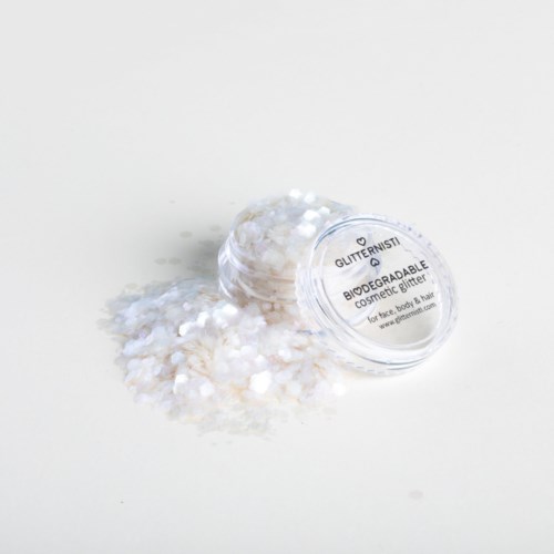 Klein doorzichtig container met glitterende cosmetische glitter, die uitgestrooid op een witte ondergrond.