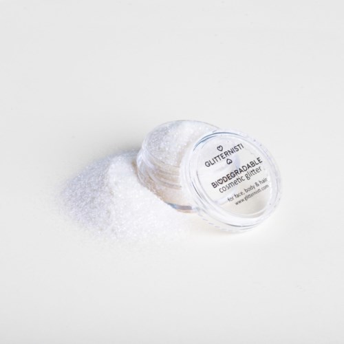 Een doorzichtige container met 'Glittermusi' ligt op een witte ondergrond, omgeven door witte glitter.