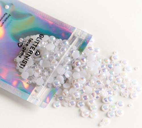 Holografische zak maakt witte en parelachtige nageldecoraties los.