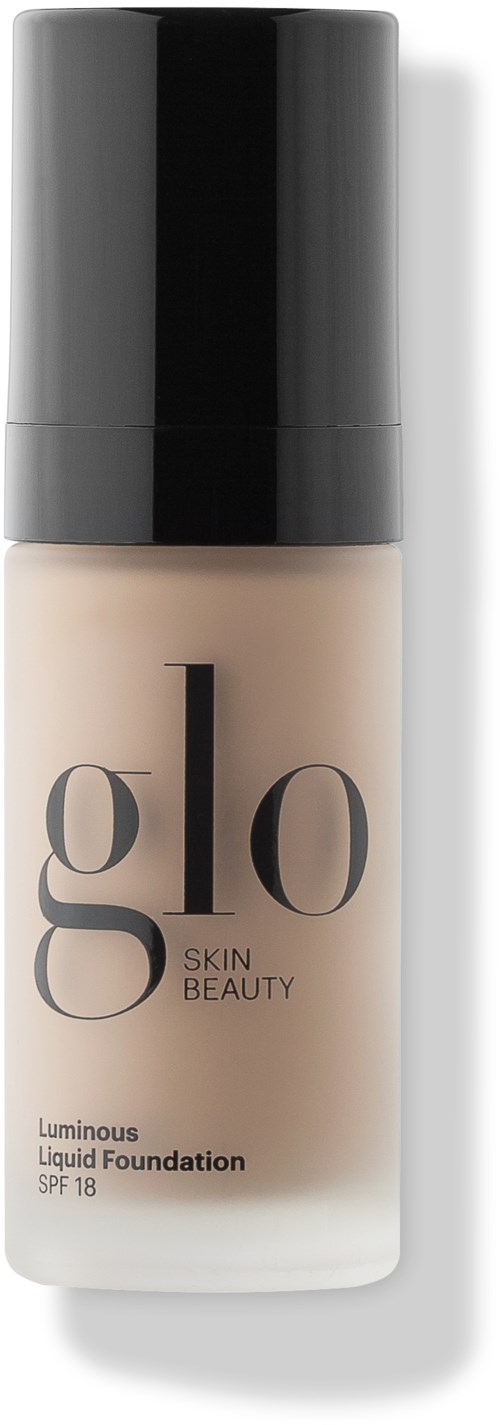 A bottle of liquid foundation with a black cap and beige liquid inside, labeled 'glo Skin Beauty Luminous Liquid Foundation SPF 18.'