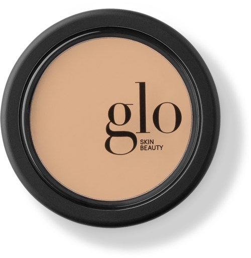 A round compact makeup case with beige powder and the brand name 'glo SKIN BEAUTY' on the lid.