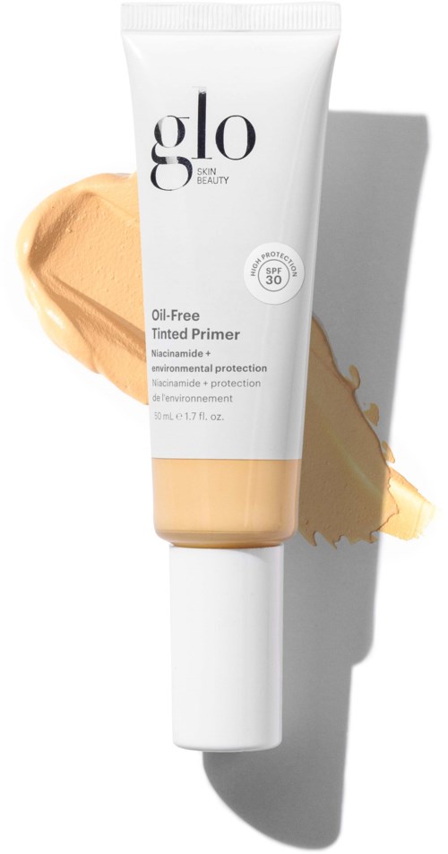 A white tube of Glo tinted primer with a beige swatch and shade label, sunlight casting a shadow.