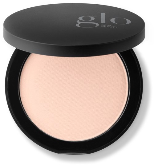 A compact powder with light beige color in a black case with a lid that says "Glo" and "BEAUTY."