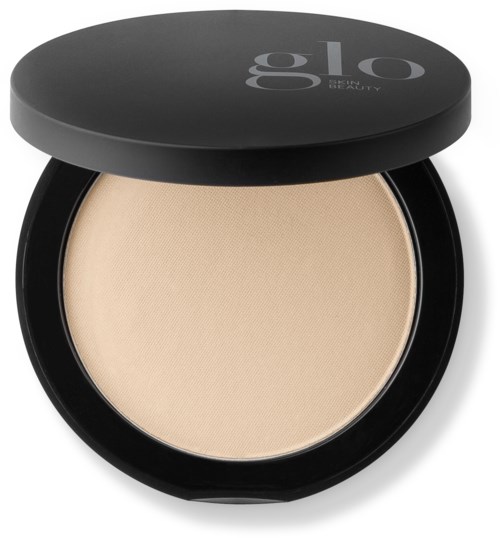 A compact with light beige face powder, black round case, and lid with gray logo. Opened, showing powder inside.