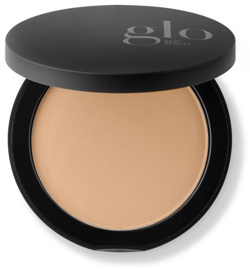 A compact with beige pressed powder and a black lid with gray text that says 'glo' for beauty products.