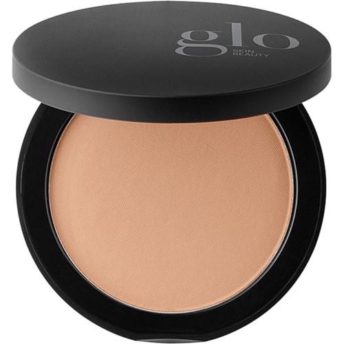 A round makeup compact with beige powder inside and a black lid showing the brand name Glo Skin Beauty.