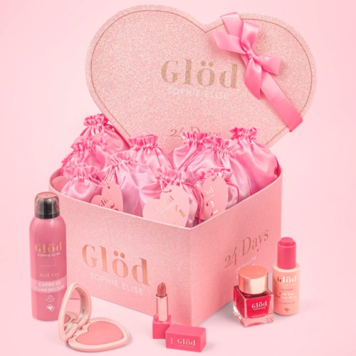 A pink gift box with a heart lid and pink ribbon, filled with pink skincare or beauty products and matching accessories.