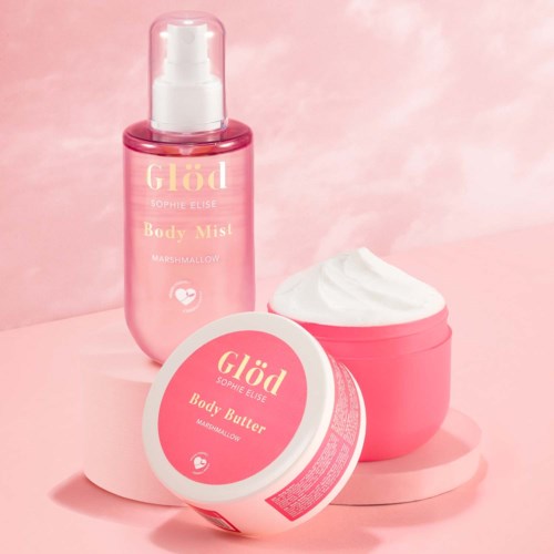 Pink bottles and jars contain body mist and body butter, with a soft pink background and white accents.