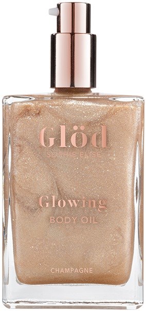 Eine klare Flasche mit einem glänzenden rosafarbenen Deckel enthält leuchtendes Körperöl in Champagnerfarbe. Text auf der Flasche lautet "Glöd" und "Glowing Body Oil."