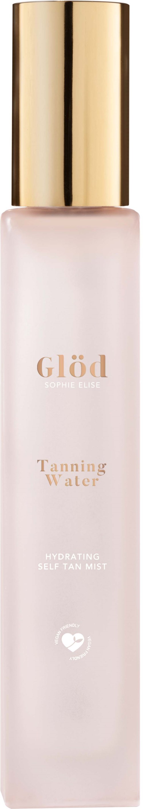 Een lange, slanke witte fles met een gouden dop, gemarkeerd Glöd Tanning Water, gebruikt voor voorbereiding op tanning.