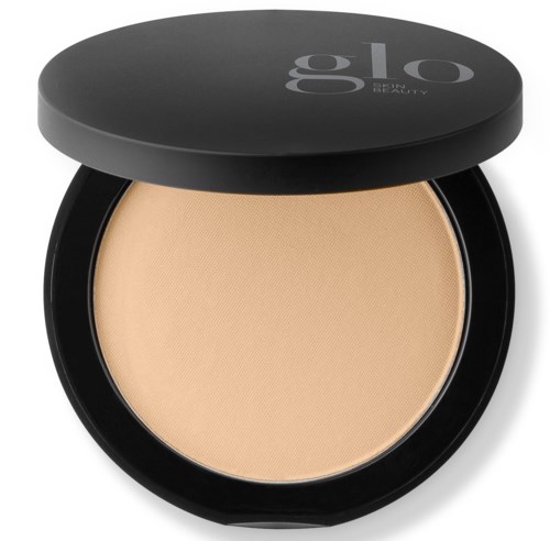 Cream makeup product in a black round compact with a closed lid.