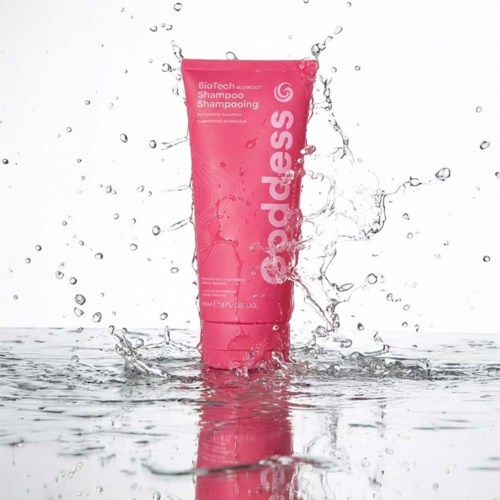 Een roze fles BioTech-shampoo met waterstralen eromheen.