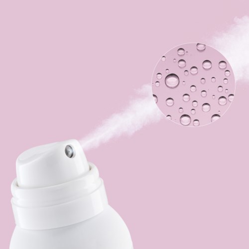 A spray can releases a fine mist with water droplets on a pink background.