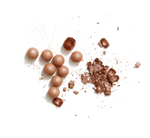 Bruine ronde snoepjes en gebroken chocolade op een witte ondergrond.