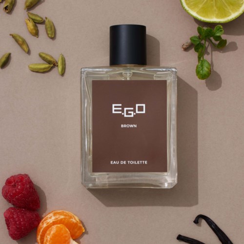 Een flesje E.G.O Brown Eau de Toilette parfumeur omgeven door limoen, munt, kardemom, framboos, mandarijn en vanille.