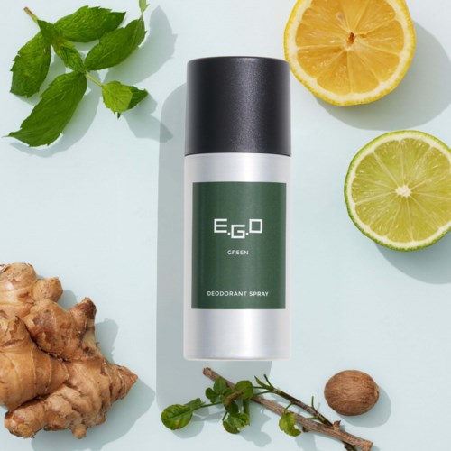 Een deodorant sprayspuit met citroen, gember, munt en nootmuskaat op een witte ondergrond.