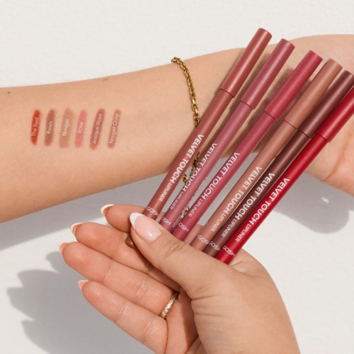 Eine Hand zeigt sechs Lippenstiftfarben am Arm, mit sechs passenden Lippenstifthülsen in der Hand.