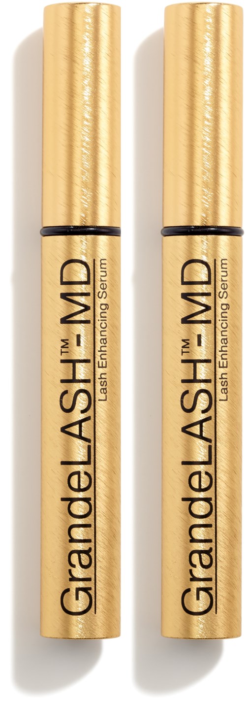 Twee goudkleurige tubes mascara staan rechtop met zwarte lijnen en tekst die hun merk en doel benadrukken.