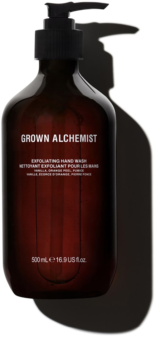 Donkerbruine fles met pomp, gelabeld "GROWN ALCHEMIST", voor handwas met vanille en sinaasappelgeur.