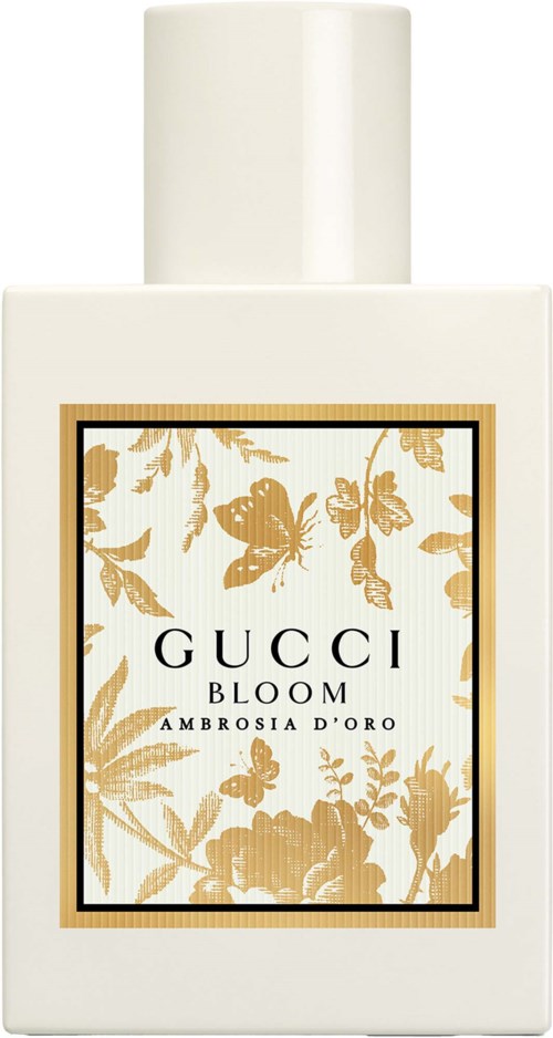 Een witte parfumfles met een gouden en witte bloemenlabel met de tekst Gucci Bloom Ambrosia D Oro.