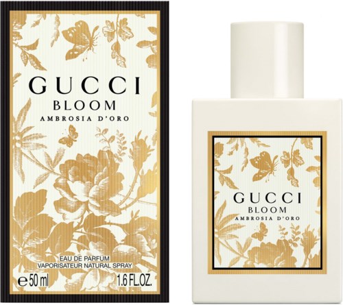 Een parfumfles en doos met gouden bloem- en vlinderontwerp, gemerkt Gucci Bloom Ambrosia D'Oro.