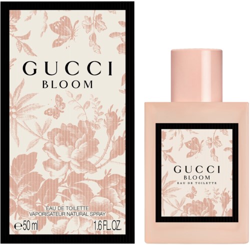 De afbeelding toont een roze parfumfles en doos voor Gucci Bloom, met bloemen- en vlinderontwerpen.