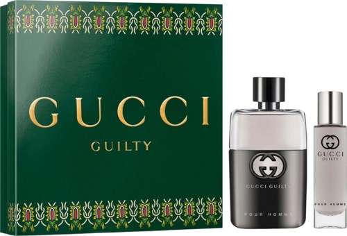 Gucci Guilty perfume set with a large green box and two bottles, one clear and one white, with black and silver caps.