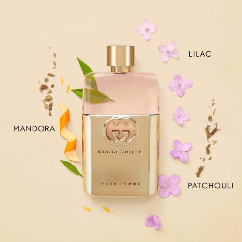 Een parfumfles met gouden dop, gemarkeerd Gucci Guilty Pour Femme, omgeven door bloembladeren en natuurlijke elementen.