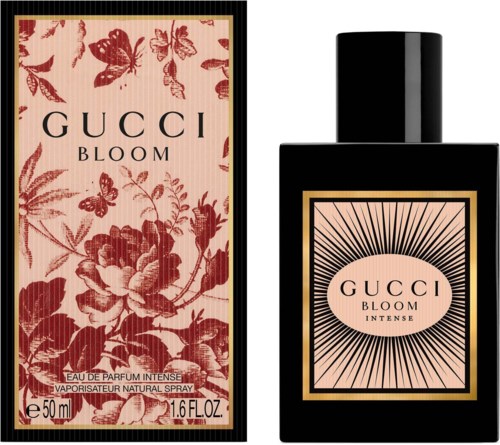 Een parfumdoos en fles met 'Gucci Bloom' en bloemen- en vlinderontwerp, roze en zwart.