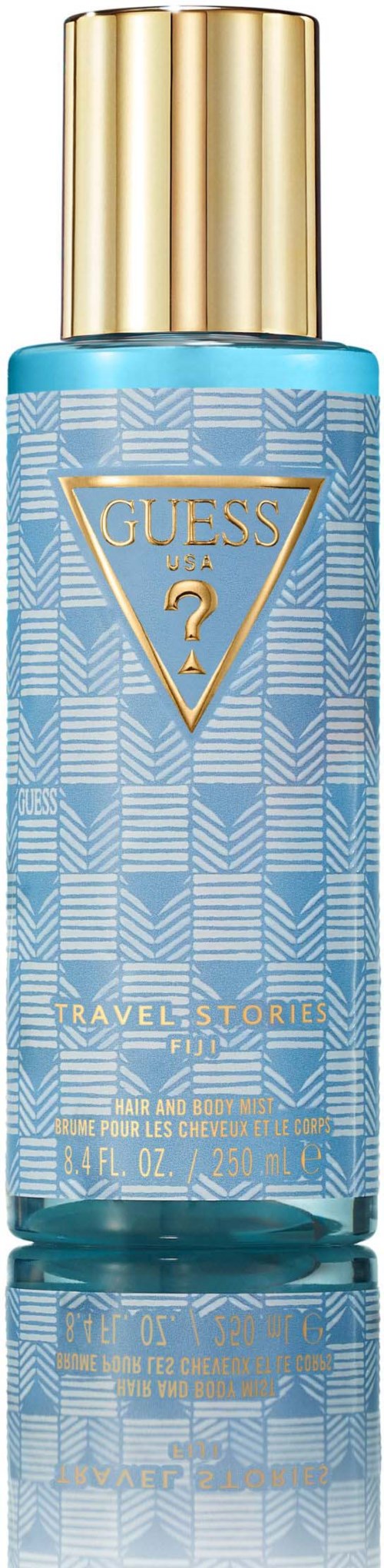 Blauwe fles met gouden dop, gelabeld Guess Travel Story, bevat haar- en lichaamsmist.