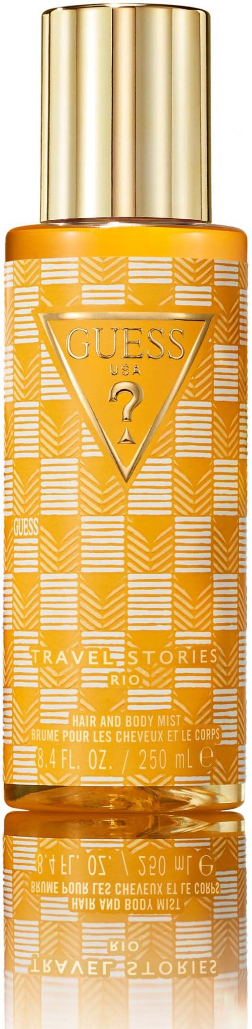 Een lange, oranje fles met een gouden deksel, gemerkt Guess, Travel Stories, en een vraagtekenlogo.