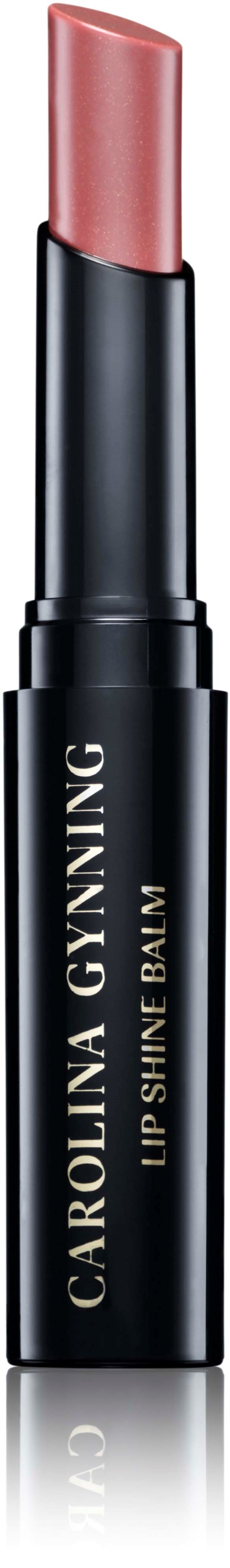 Ein Lippenstift in schwarzem Röhrchen mit beigem Deckel, beschriftet "Carolina Gynning Lip Shine Balm."