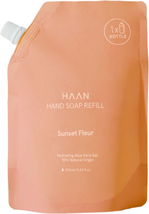 Eine pfirsichfarbene Nachfüllpackung für Handseife mit weißem Deckel oben links, beschriftet "Haan Hand Soap Refill" und "Sunset Fleur."